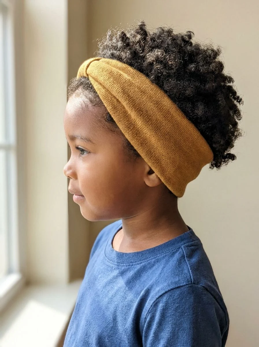 Soft mustard headband holding back loose short curls.