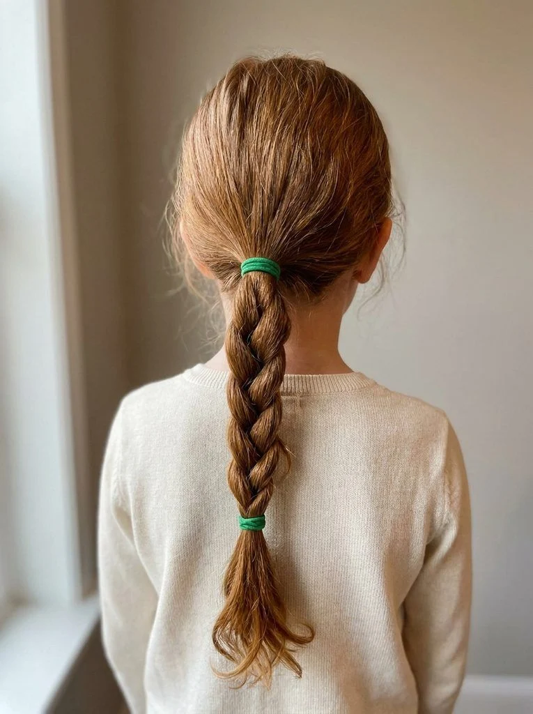 Mid-height ponytail braided down its length with matching green ties.