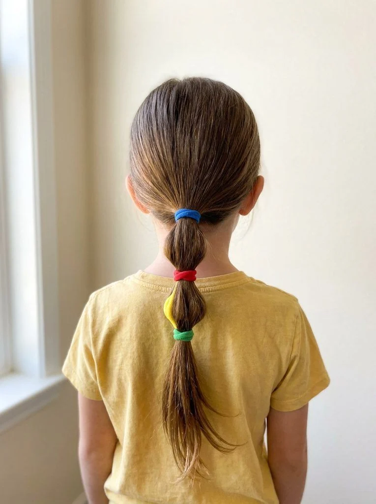 Bubble ponytail with three rounded sections and colorful hair ties.