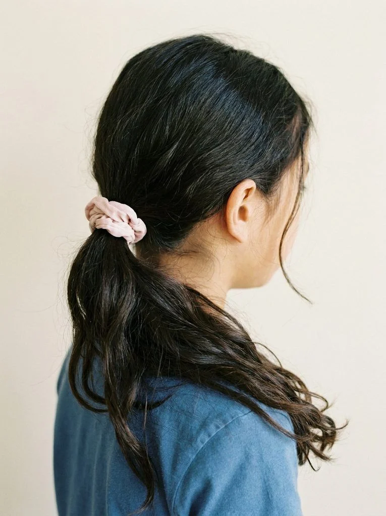 Simple three-strand braid starting at the nape and secured with a blue tie.