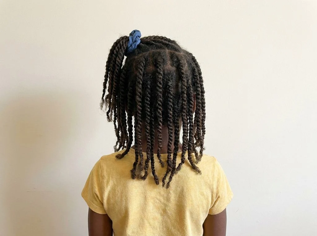 Existing two-strand twists arranged into a loose half-up ponytail.