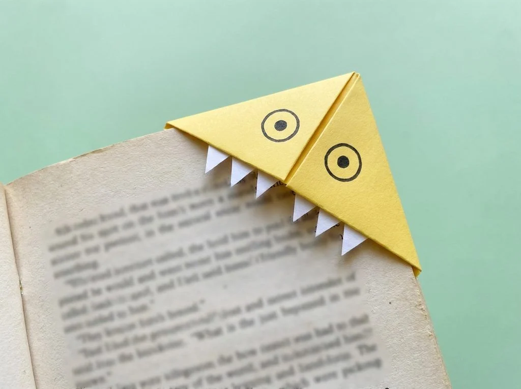Yellow monster corner bookmark fitted over the corner of a book page.